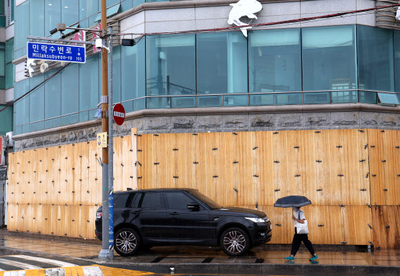 제6호 태풍 ‘카눈’이 북상하고 있는 9일 부산 수영구 민락수변공원에 있는 한 상가가 월파에 대비해 합판이 유리에 덧대어져 있다. 2023.8.9 연합뉴스
