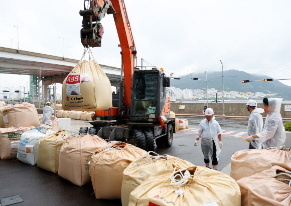 제6호 태풍 ‘카눈’이 북상하고 있는 9일 부산 서구 송도해수욕장 인근 한 주상복한 건물 입구에 대형 모래주머니가 쌓이고 있다. 이곳은 지난해 태풍 힌남노 때 월파 피해를 겪은 곳이다. 2023.8.9 연합뉴스