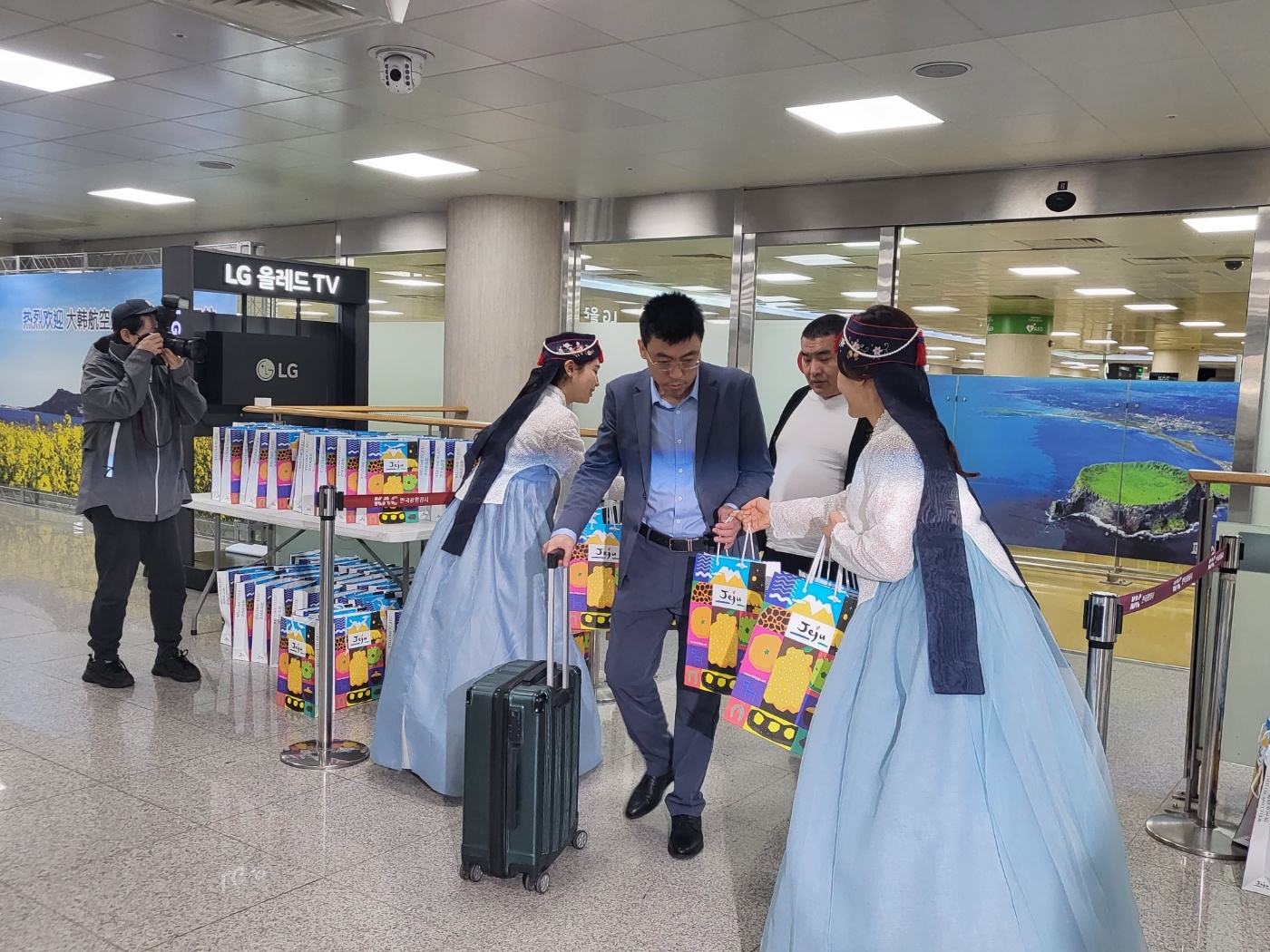 지난 5월 1일 대한항공이 3년만에 제주~베이징 직항 재취항을 기념해 제주를 찾은 중국관광객들에게 기념품을 선물하고 있다.  제주 강동삼 기자