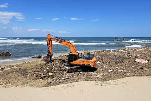 11일 강원 강릉시 정동진 해변에서 중장비가 태풍의 영향으로 백사장에 밀려든 쓰레기들을 치우고 있다. 2023.8.11 연합뉴스