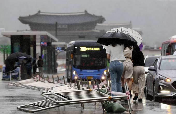 태풍 ‘카눈’이 북상 중인 10일 오후 서울 광화문 광장에서 시민들이 비바람을 맞으며 힘겹게 걸어가고 있다. 연합뉴스