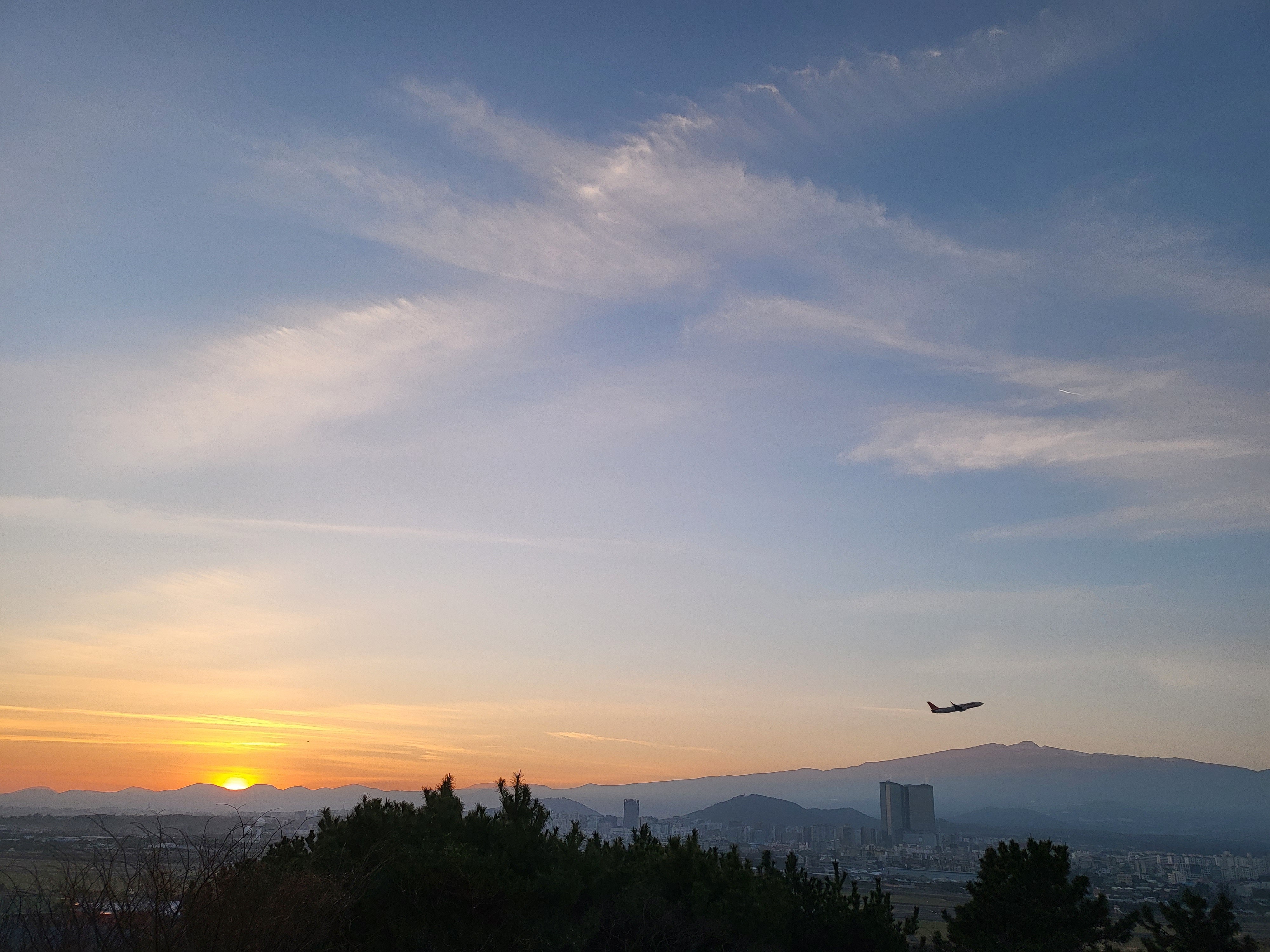 제주시 도두봉 정상에서 바라본 일출 장관. 해뜰 무렵 제주국제공항 활주로에서 비행기가 이륙해 힘차게 비상하고 있다. 제주 강동삼 기자