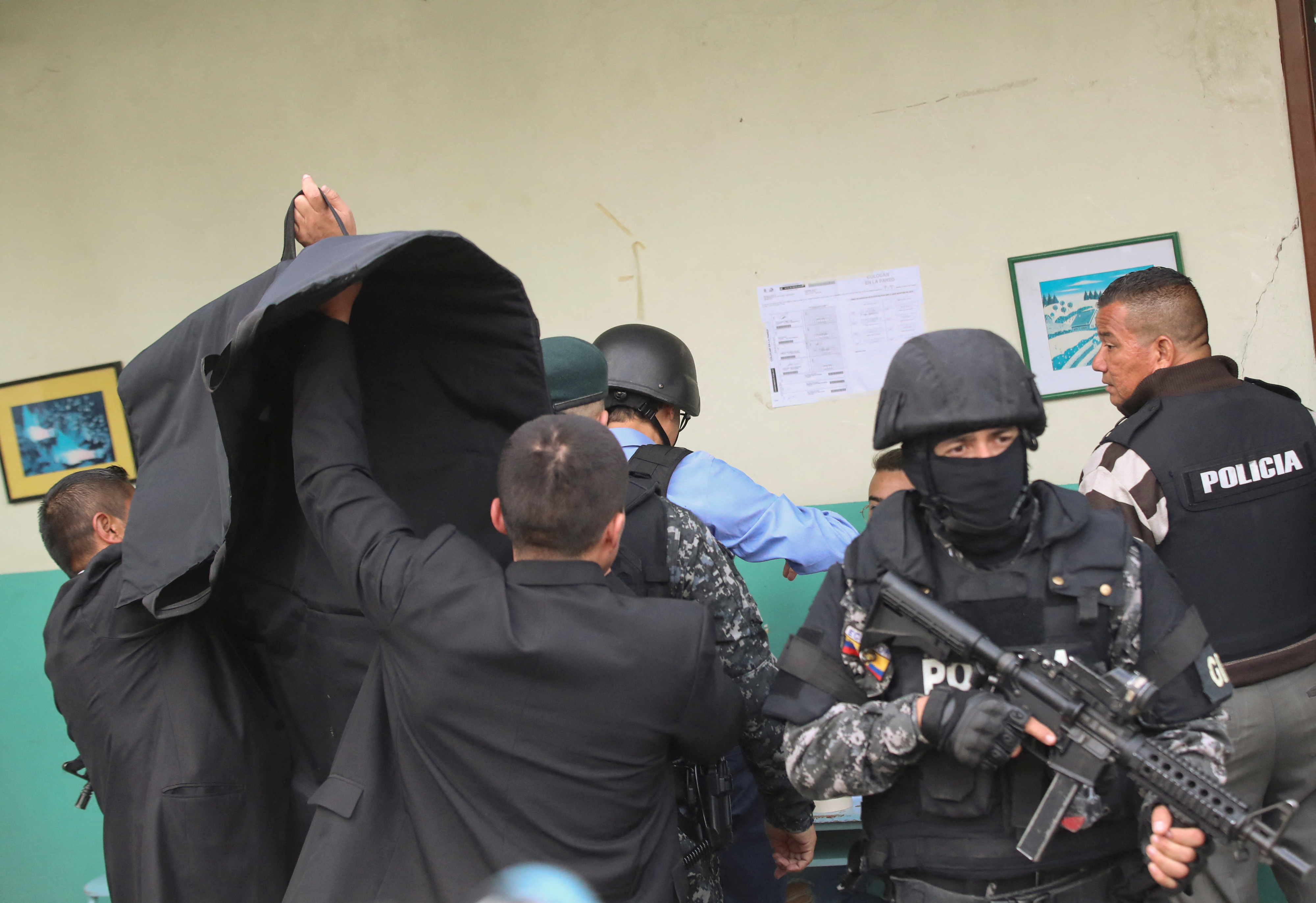 에콰도르 경찰이 투표하는 주리타 후보의 뒤를 암막으로 가리고 있는 모습. 키토 로이터 연합뉴스