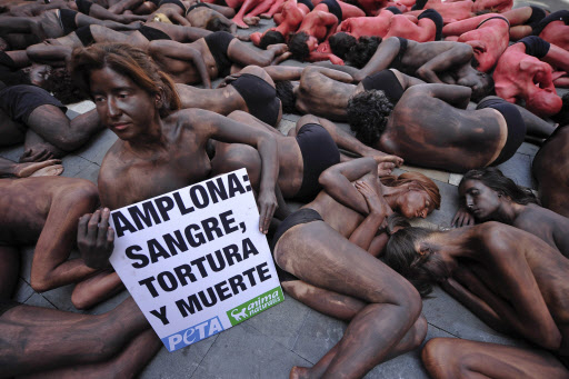 투우에 반대하는 동물활동가들이 ‘산페르민 축제’의 시작에 앞서 온몸에 붉은색과 검은색을 칠하고 시위를 벌였다. 한 시위자는 ‘팜플로나: 피투성이의 고문과 죽음’이라고 적힌 플래카드를 들고 있다. AP=연합뉴스