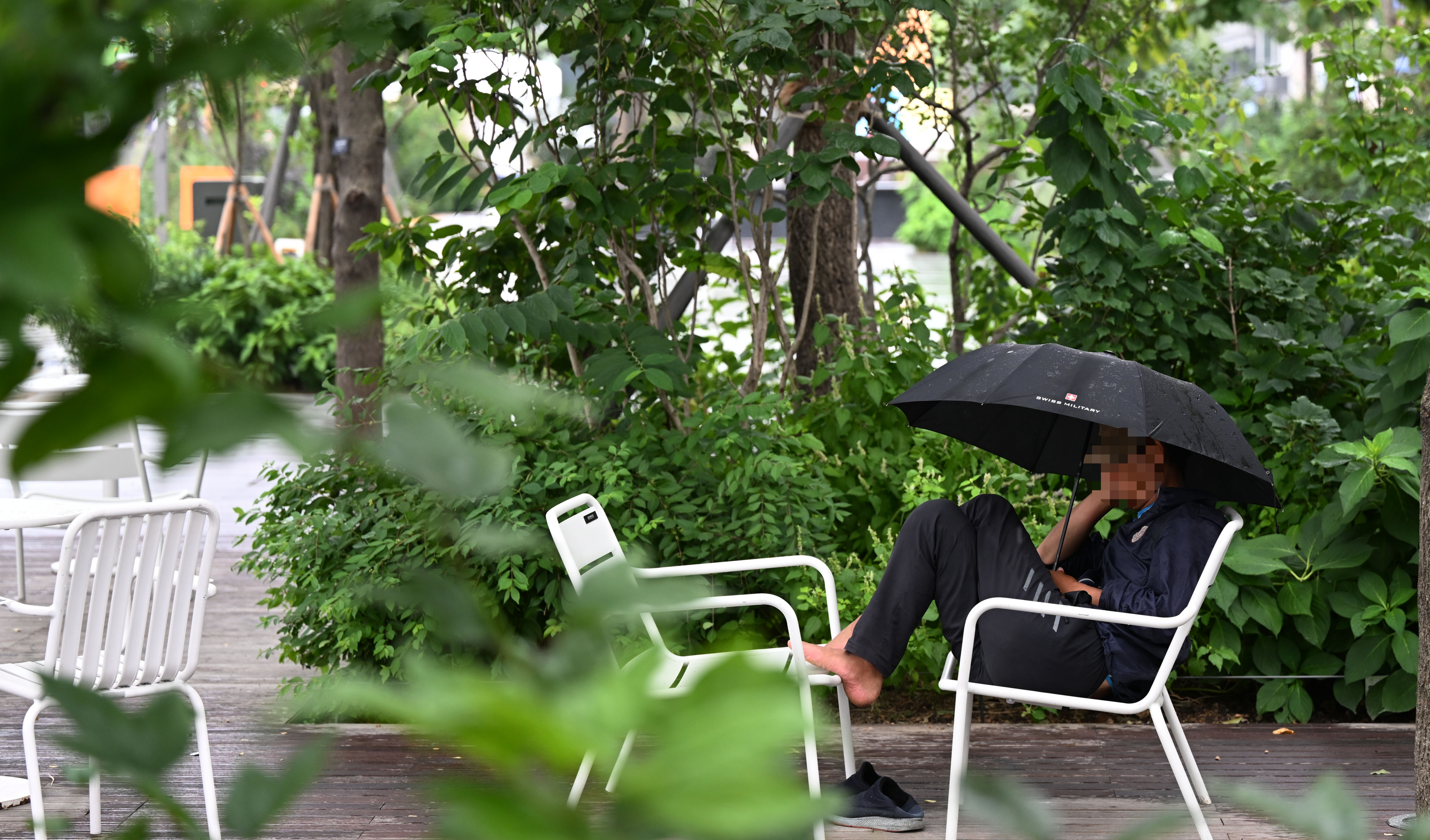 비가 내리는 22일 서울 광화문광장에서 한 시민이 우산을 쓰고 의자에 앉고 휴식을 취하고 있다. 2023.8.22 오장환 기자