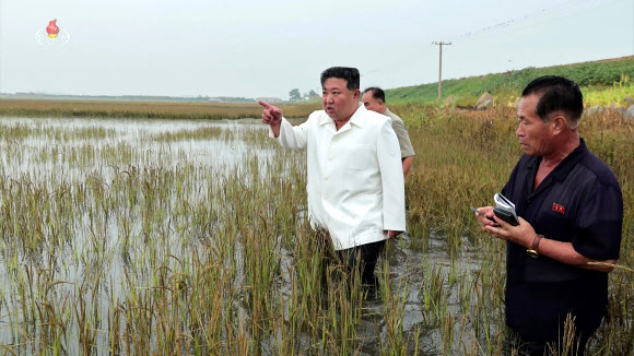 김정은 북한 국무위원장이 지난 21일 평안남도 간석지건설종합기업소 안석간석지 피해복구 현장을 현지지도 했다고 조선중앙통신이 22일 보도했다. 김 위원장이 흰색 상의와 검은색 바지를 입고 물에 잠긴 논에 직접 들어가 피해 현장을 둘러보고 있다. 2023.8.22. 조선중앙TV 화면·연합뉴스