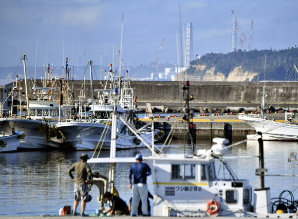 기시다 후미오 일본 총리가 22일 후쿠시마 제1원자력발전소 오염수(일본 정부 명칭 ‘처리수’)의 해양 방류 개시와 관련해 “기상 등 지장이 없으면 24일로 예상한다”고 밝혔다.  사진은 이날 오전  후쿠시마 제1원자력발전소 인근 포구에서 바라본 배기통. 2023.8.22. 교도 연합뉴스