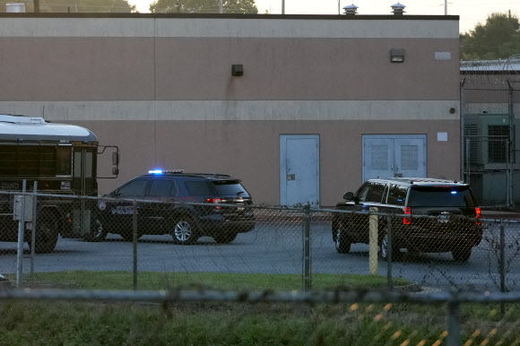 도널드 트럼프 전 대통령(오른쪽)을 태운 차량이 24일 애틀랜타 풀턴 카운티 교도소에 도착하고 있다. AP연합뉴스
