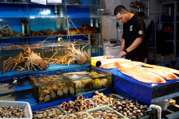 24일 중국 베이징 수산물 시장에서 상인이 해산물을 손질하고 있다. 2023.08.25 베이징 로이터 연합뉴스