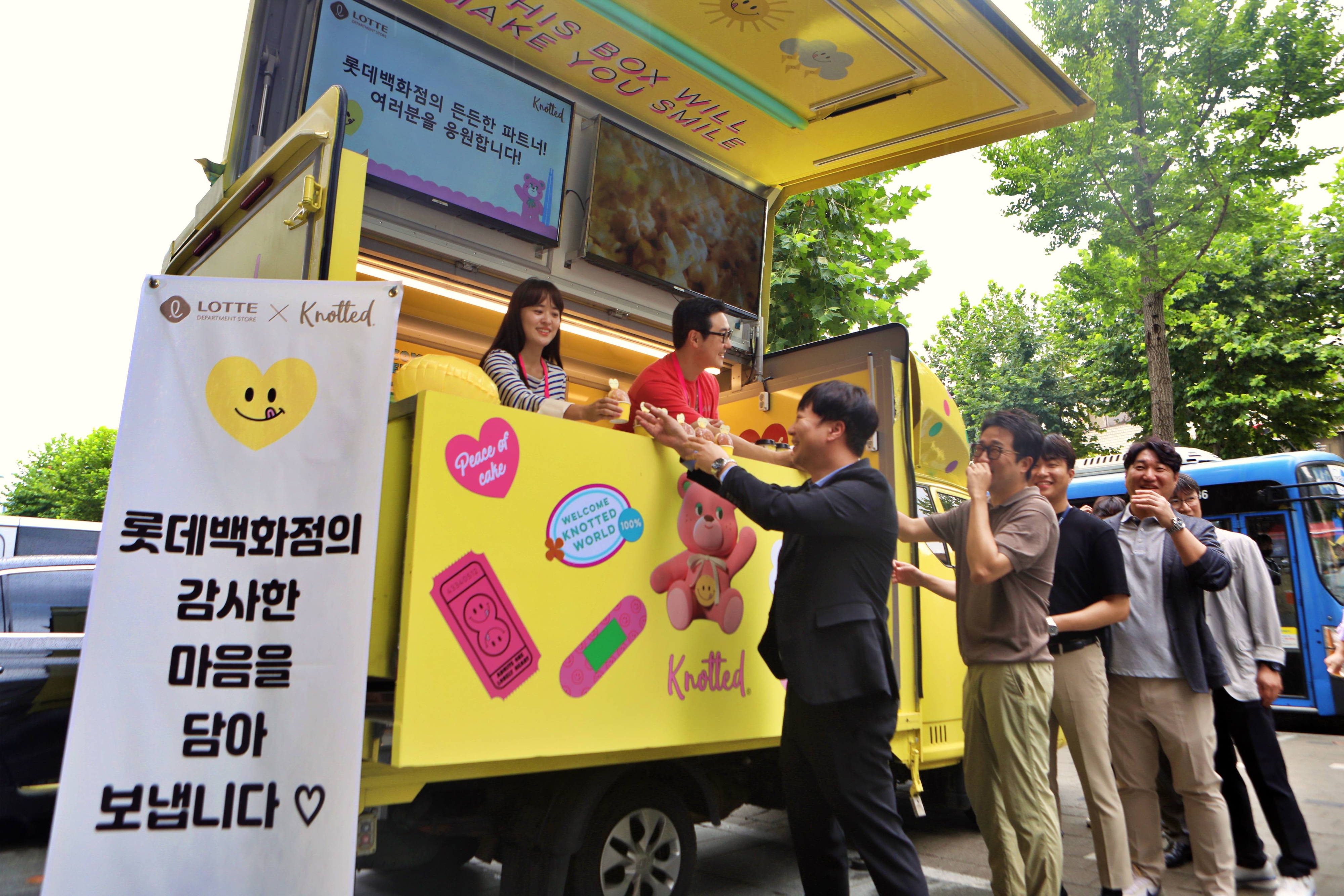 롯데백화점이 마련한 커피차에서 파트너사 임직원들이 간식을 받아가고 있다. 롯데백화점 제공