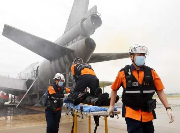30일 오후 인천국제공항 모형항공기 소방훈련장에서 진행된 항공기사고 위기대응훈련에서 구조대원들이 심폐소생술을 하며 부상자를 이송하고 있다. 이날 훈련에는 인천국제공항공사, 서울지방항공청, 영종소방서, 인천국제공항경찰단 등 17개 기관이 참여해 강풍으로 착륙에 실패한 항공기가 복행을 시도하다 활주로 담장과 충돌하는 상황을 가정해 훈련을 진행했다. 2023.8.30 연합뉴스