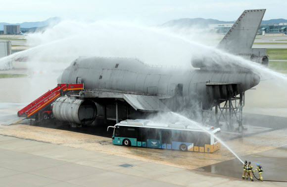 30일 오후 인천국제공항 모형항공기 소방훈련장에서 진행된 항공기사고 위기대응훈련에서 소방관들이 화재 진압을 위해 물을 뿌리고 있다. 이날 훈련에는 인천국제공항공사, 서울지방항공청, 영종소방서, 인천국제공항경찰단 등 17개 기관이 참여해 강풍으로 착륙에 실패한 항공기가 복행을 시도하다 활주로 담장과 충돌하는 상황을 가정해 훈련을 진행했다. 2023.8.30. 공동취재