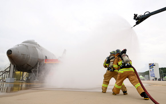 30일 오후 인천국제공항 모형항공기 소방훈련장에서 진행된 항공기사고 위기대응훈련에서 소방대원들이 화재를 진압하고 있다. 이날 훈련에는 인천국제공항공사, 서울지방항공청, 영종소방서, 인천국제공항경찰단 등 17개 기관이 참여해 강풍으로 착륙에 실패한 항공기가 복행을 시도하다 활주로 담장과 충돌하는 상황을 가정해 훈련을 진행했다. 2023.8.30 연합뉴스