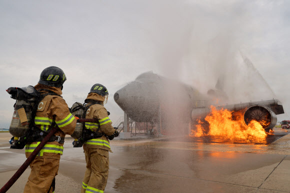 30일 오후 인천국제공항 모형항공기 소방훈련장에서 진행된 항공기 사고 위기대응훈련에서 소방대원들이 화재를 진압하고 있다. 이날 훈련에는 인천국제공항공사, 서울지방항공청, 영종소방서, 인천국제공항경찰단 등 17개 기관이 참여해 강풍으로 착륙에 실패한 항공기가 복행을 시도하다 활주로 담장과 충돌하는 상황을 가정해 훈련을 진행했다. 2023.8.30 연합뉴스