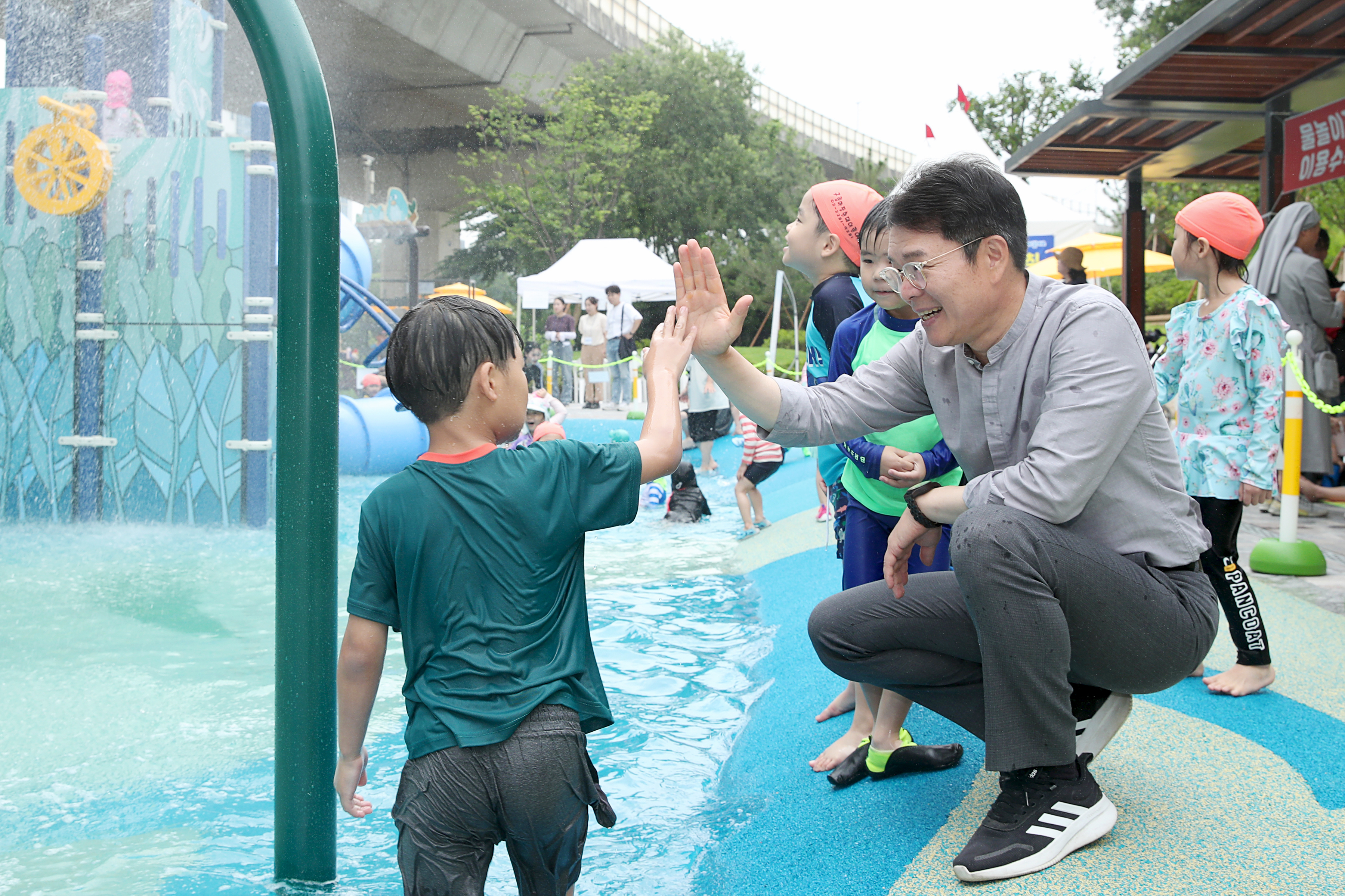 정원오(오른쪽) 서울 성동구청장이 성동구가 운영하는 물놀이장을 찾은 아이와 인사하고 있다. 성동구 제공