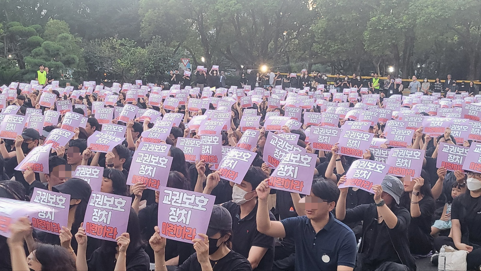 4일 제주도교육청 앞마당에서 열린 공교육 멈춤의 날, 추모 문화제에 참석한 교사들이 맨바닥에 앉아 주최측이 나눠 준 피켓을 들며 구호를 외치고 있다. 제주 강동삼 기자