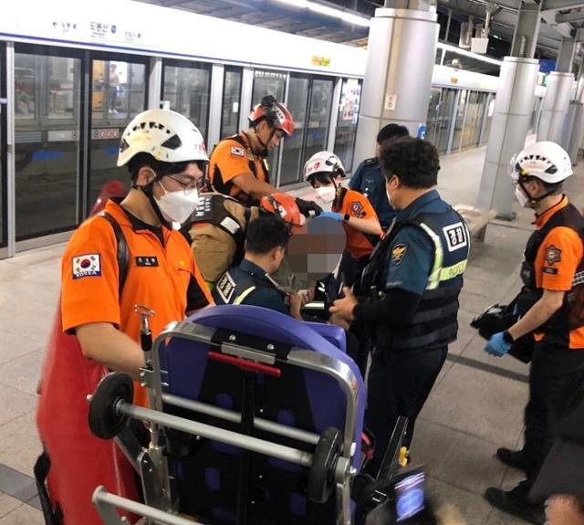 지난 3일 서울 도봉구 서울지하철 1호선 도봉산역에서 선로에 추락한 60대 남성이 시민들에게 구조된 뒤 출동한 구급대원의 치료를 받고 있다. 도봉소방서 제공