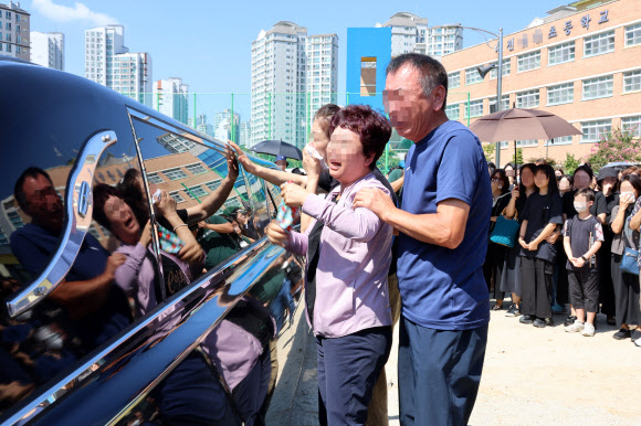 악성민원으로 세상을 뜬 대전 초등 교사의 운구 차량이 9일 오전 교사가 재직하던 유성구 한 초등학교에 들러 마지막 인사를 하자, 유족들이 운구 차량에 기대 오열하고 있다. 2023.9.9 연합뉴스