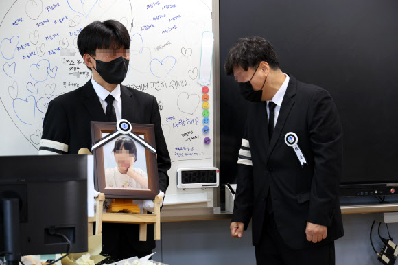 악성민원으로 세상을 뜬 대전 초등 교사의 유족들이 9일 오전, 교사가 재직하던 유성구 한 초등학교 5학년 교실에 영정사진을 들고 들어서며 눈물을 흘리고 있다. 2023.9.9 연합뉴스