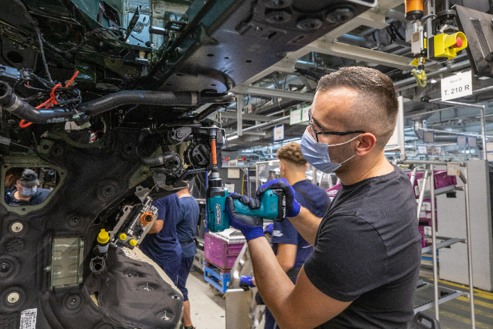 독일 BMW 뮌헨 공장의 한 직원이 전동 드릴로 전기차 ‘i4’의 부품을 조립하고 있다. BMW 제공