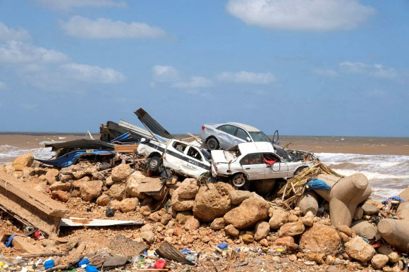 지난 9일(현지시간) 폭풍 다니엘의 여파가 큰 비가 내려 둑 두 곳이 무너지는 바람에 큰 홍수가 발생한 리비아 동부 데르나 항구 하류 언저리에 12일 물난리에 쓸려간 자동차들이 쌓여 있다. 데르나 로이터 연합뉴스