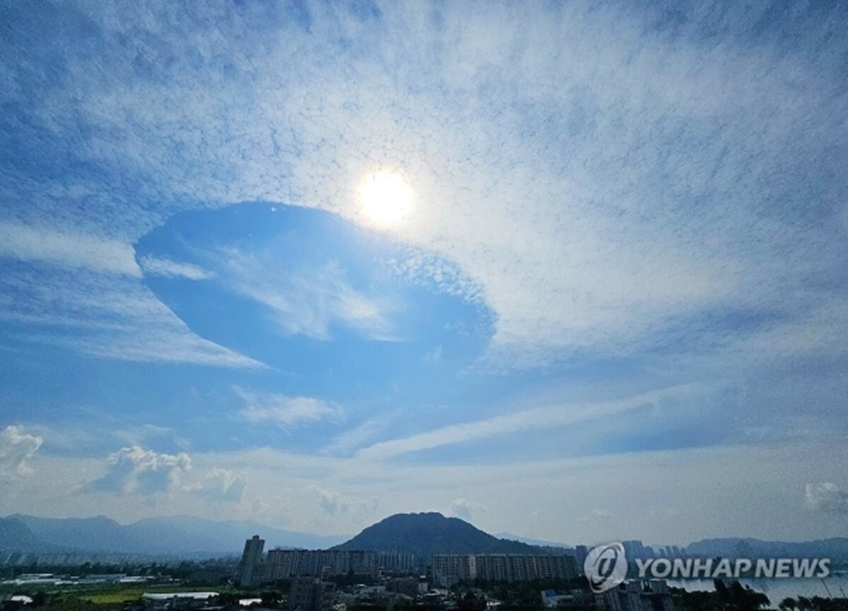 12일 강원 춘천 도심 하늘 위로 구멍이 난 듯 독특한 모양의 구름이 펼쳐져 있다. 연합뉴스