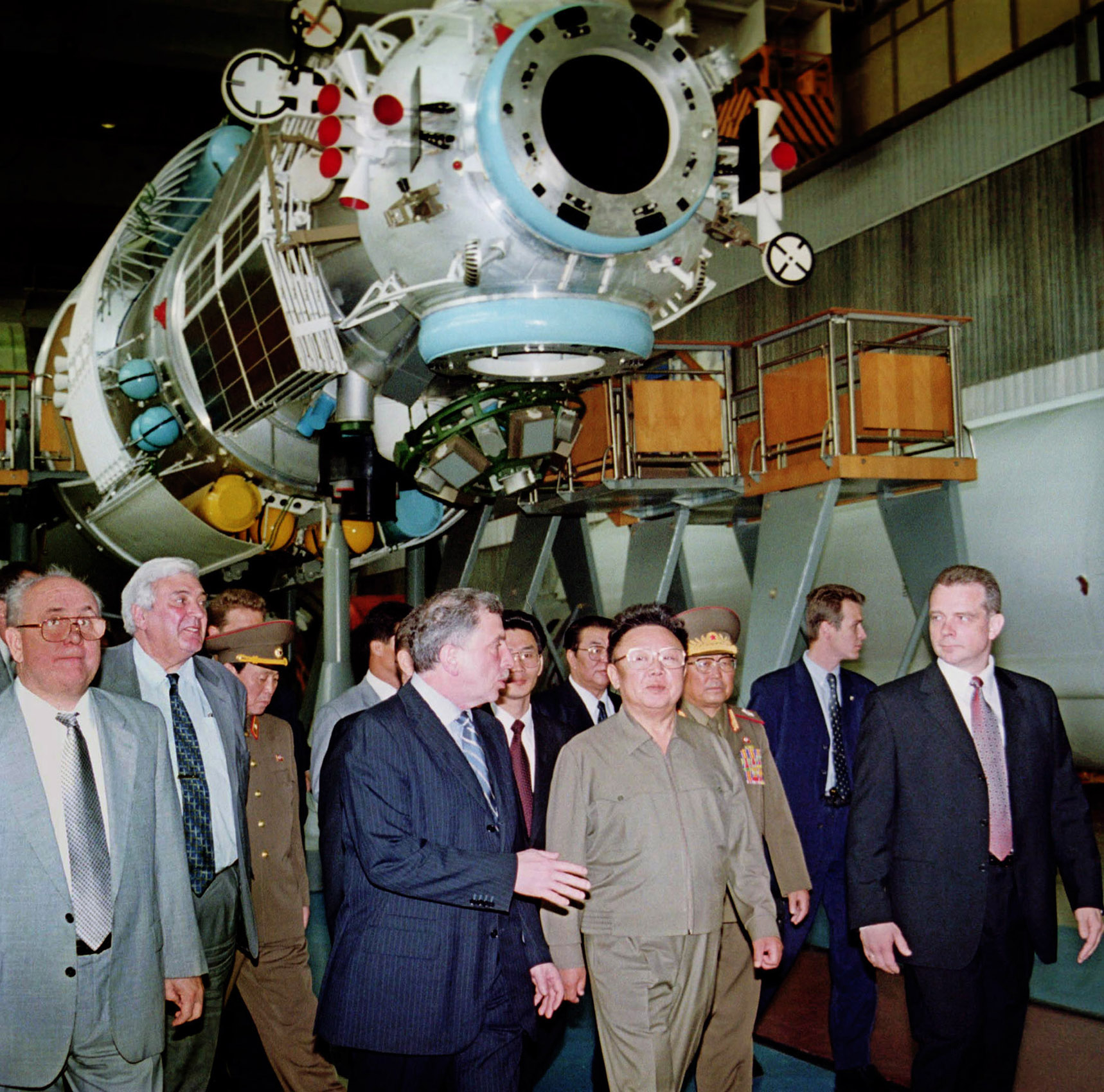 2001년 8월 5일 일요일, 북한 지도자 김정일(오른쪽에서 네 번째)이 러시아 부총리 일리야 클레바노프(왼쪽에서 네 번째)가 모스크바 외곽 흐루니체프 우주센터를 방문하는 동안 실제 크기의 모형을 들고 듣고 있다. 배경에 있는 미르 궤도 우주 정거장의 크리스탈(Crystal) 모듈. 또한 왼쪽에서 두 번째 러시아 항공우주국의 유리 코프테프(Yuri Koptev) 국장과 흐루니체프 주립 우주센터 소장 알렉산더 메드베데프(Alexander Medvedev)도 함께 있습니다. 김 위원장은 블라디미르 푸틴 러시아 대통령과 회담을 갖고 두 이념 동맹국 사이의 새로운 전략적 동맹을 선보인 지 하루 만에 일요일 러시아의 우주 과학 시설을 견학했다. 서울신문DB