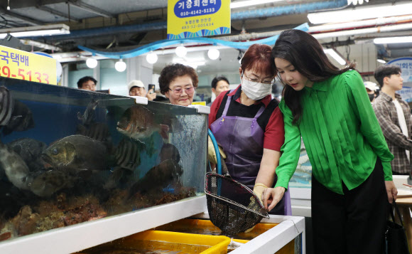 윤석열 대통령 부인 김건희 여사가 14일 부산 기장시장을 찾아 생선 등 수산물을 살펴보고 있다.  2023.9.14 연합뉴스