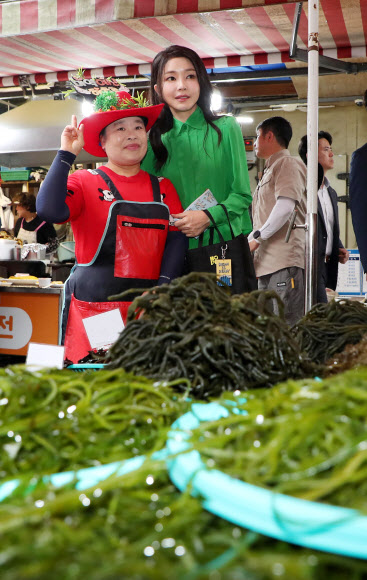 윤석열 대통령 부인 김건희 여사가 14일 부산 기장시장을 찾아 다시마, 미역 등을 살펴보며 상인과 기념 사진을 찍고 있다. 2023.9.14 연합뉴스