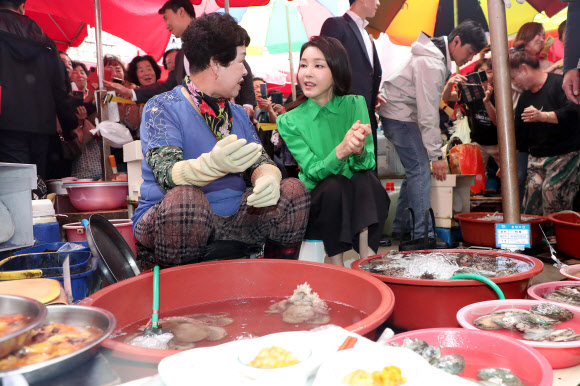 윤석열 대통령 부인 김건희 여사가 14일 부산 기장시장을 찾아 성게, 전복을 살펴보며 상인과 대화하고 있다.  2023.9.14 연합뉴스
