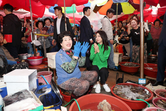 윤석열 대통령 부인 김건희 여사가 14일 부산 기장시장을 찾아 시민들의 환호에 박수치고 있다.   2023.9.14 연합뉴스