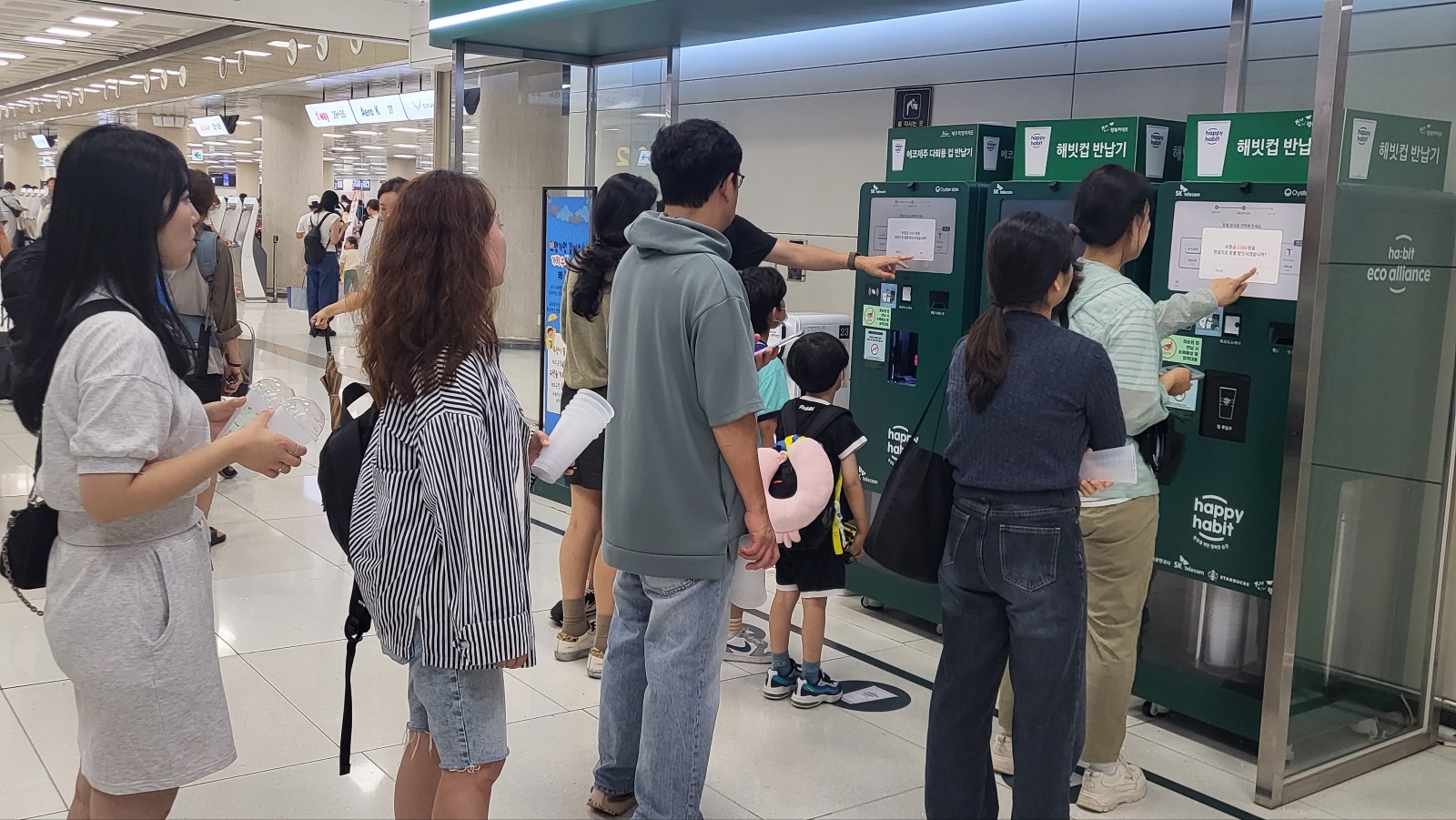 제주도를 찾은 관광객들이 17일 제주공항에 설치된 다회용컵 반납기에 컵을 반납하고 있다.