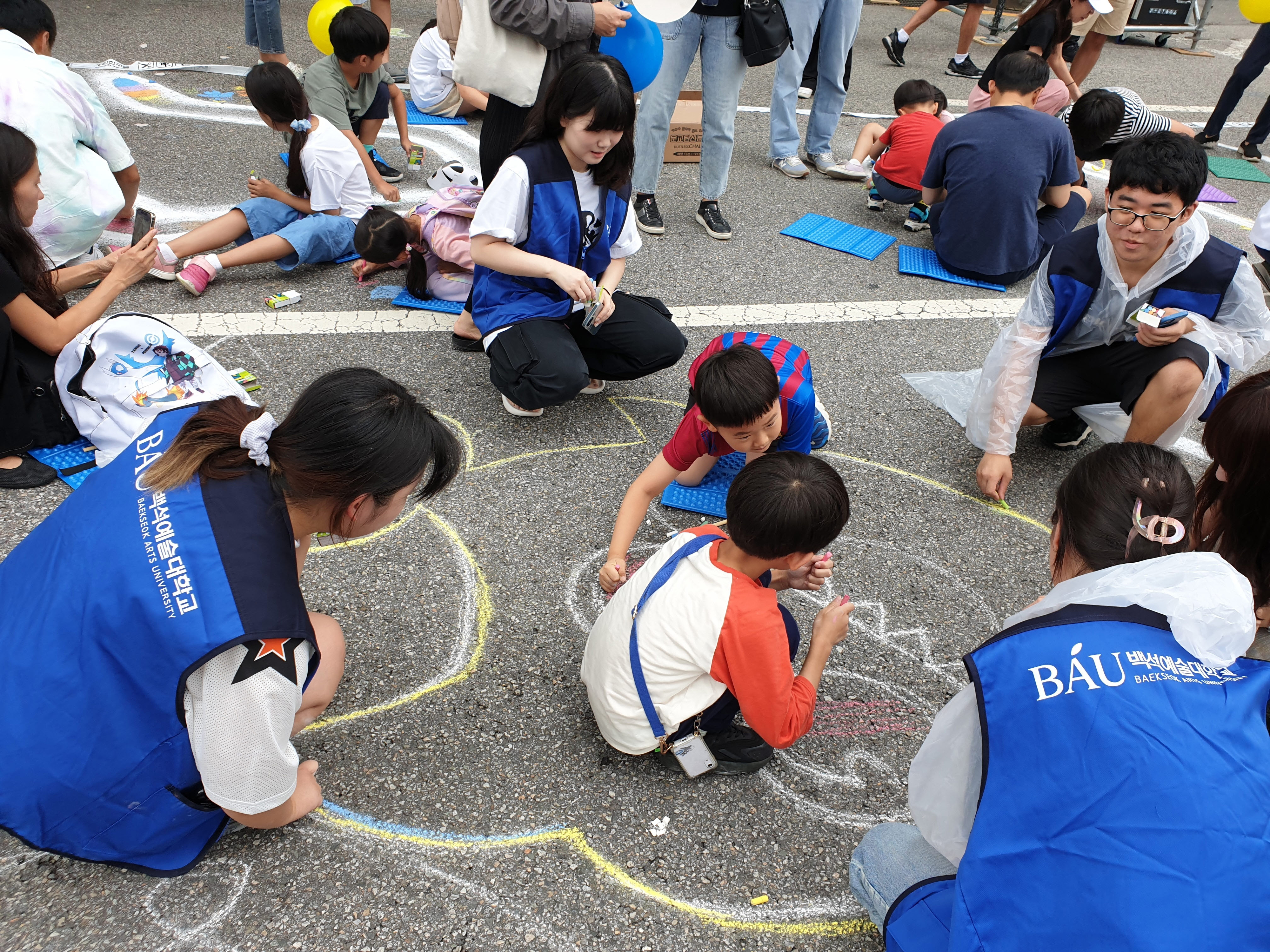 서리풀페스티벌 ‘지상최대 스케치북’ 대규모 거리 드로잉 행사에 참여한 백석예대 디자인미술학부 학생들이 어린이들과 함께 그림을 그리고 있다. 백석예대 제공