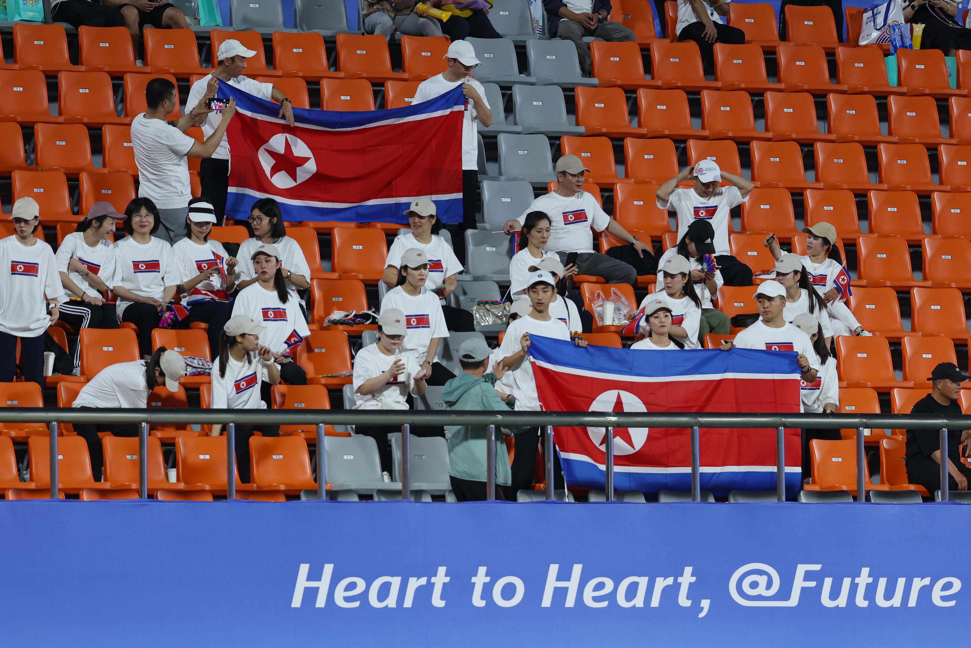 21일 오후 중국 저장성 진화 저장성사범대동쪽경기장에서 열린 2022 항저우 아시안게임 남자 축구 예선 F조 2차전 키르기스스탄과 북한의 경기에 앞서 북한 응원단이 인공기를 펼치고 있다.   연합뉴스