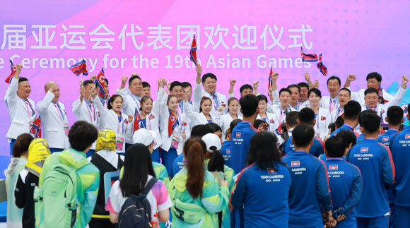 2022 항저우 아시안게임(AG) 개막을 하루 앞둔 22일 북한 선수단이 중국 항저우시 아시안게임 선수촌 국기광장에서 열린 공식 입촌식을 마친 뒤 무대에 올라 구호를 외치며 기념촬영을 하고 있다. 2023.9.22 연합뉴스