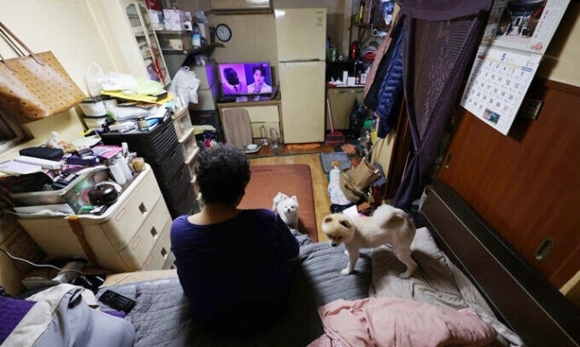 한 쪽방촌에서 두 마리의 강아지와 지내는 한 어르신의 모습. 연합뉴스