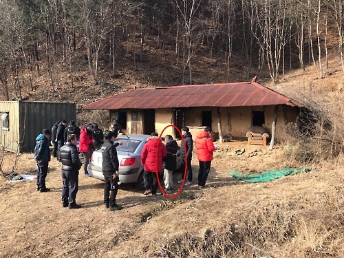 2017년 1월 홍천군의 한 폐가에서 한씨(빨간색 동그라미)가 범행을 재연하고 있다.