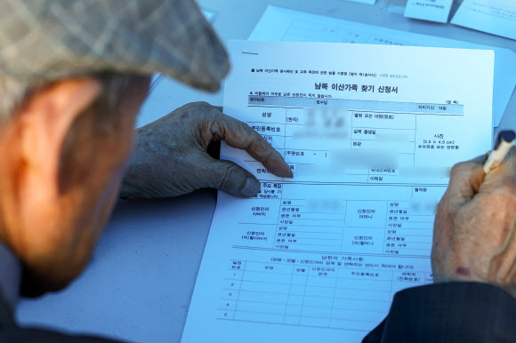 제1회 이산가족의 날인 27일 오후 서울 종로구 광화문광장에서 열린 문화행사에서 한 이산가족 시민이 이산가족 찾기 신청서를 작성하고 있다. 2023.9.27 연합뉴스
