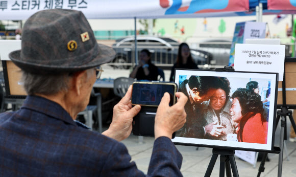 제1회 이산가족의 날인 27일 오후 서울 종로구 광화문광장에서 열린 문화행사에서 한 시민이 이산가족 사진전을 감상하고 있다. 2023.9.27 연합뉴스