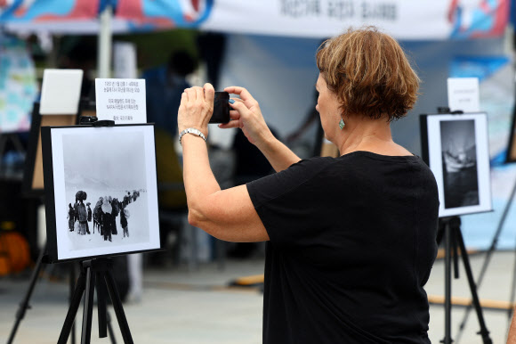 제1회 이산가족의 날인 27일 오후 서울 종로구 광화문광장에서 열린 문화행사에서 한 관광객이 이산가족 사진을 감상하고 있다. 2023.9.27 연합뉴스