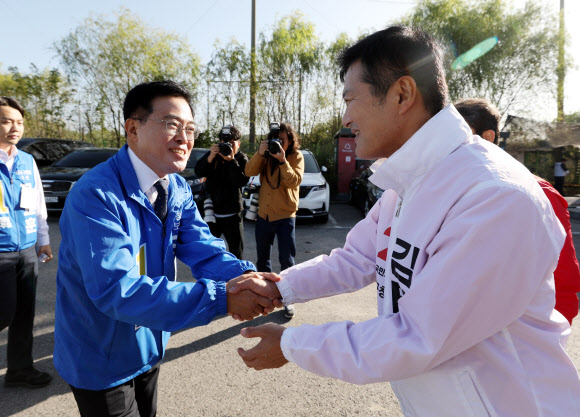 진교훈 더불어민주당 강서구청장 후보와 김태우 국민의힘 강서구청장 후보가 5일 오전 인천 계양구 강서개화축구장에서 열린 강서부동산연합협동조합 한마음 체육대회에서 유세활동을 하던 중 인사를 나누고 있다. 2023.10.05 뉴시스