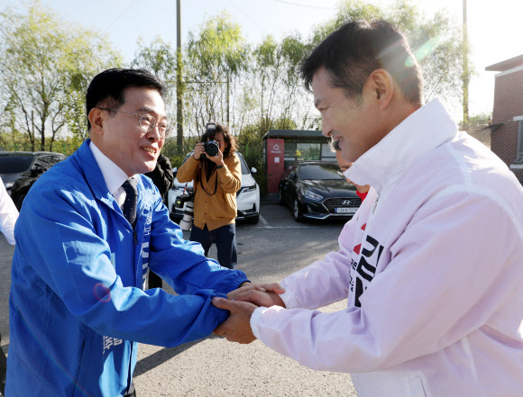진교훈 더불어민주당 강서구청장 후보와 김태우 국민의힘 강서구청장 후보가 5일 오전 인천 계양구 강서개화축구장에서 열린 강서부동산연합협동조합 한마음 체육대회에서 유세활동을 하던 중 인사를 나누고 있다. 2023.10.05 뉴시스