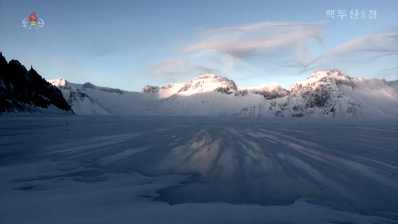 북한 조선중앙TV는 5일 올해 조선기록과학영화촬영소에서 제작한 기록영화 ‘백두산 8경’을 방영했다. 영화는 백두산의 웅장한 절경을 드론을 활용해 생생하게 담아냈다. 영화는 백두산 8경인 백두산의 해돋이, 향도봉의 친필글발, 삼천리조국땅이 바라보이는 장군봉, 백두연봉의 웅장한 자태, 장쾌하고 우아한 천지, 떼지어 노는 천지산천어, 눈속에 핀 만병초, 백두의 칼바람을 차례로 소개했다. 백두산은 1989년 4월에 세계생물권보호구로 유네스코에 등록되었다. 2023.10.5. 조선중앙TV 화면·연합뉴스