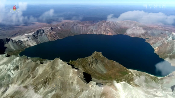 북한 조선중앙TV는 5일 올해 조선기록과학영화촬영소에서 제작한 기록영화 ‘백두산 8경’을 방영했다. 영화는 백두산의 웅장한 절경을 드론을 활용해 생생하게 담아냈다. 영화는 백두산 8경인 백두산의 해돋이, 향도봉의 친필글발, 삼천리조국땅이 바라보이는 장군봉, 백두연봉의 웅장한 자태, 장쾌하고 우아한 천지, 떼지어 노는 천지산천어, 눈속에 핀 만병초, 백두의 칼바람을 차례로 소개했다. 백두산은 1989년 4월에 세계생물권보호구로 유네스코에 등록되었다. 2023.10.5. 조선중앙TV 화면·연합뉴스