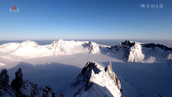 북한 조선중앙TV는 5일 올해 조선기록과학영화촬영소에서 제작한 기록영화 ‘백두산 8경’을 방영했다. 영화는 백두산의 웅장한 절경을 드론을 활용해 생생하게 담아냈다. 영화는 백두산 8경인 백두산의 해돋이, 향도봉의 친필글발, 삼천리조국땅이 바라보이는 장군봉, 백두연봉의 웅장한 자태, 장쾌하고 우아한 천지, 떼지어 노는 천지산천어, 눈속에 핀 만병초, 백두의 칼바람을 차례로 소개했다. 백두산은 1989년 4월에 세계생물권보호구로 유네스코에 등록되었다. 2023.10.5. 조선중앙TV 화면·연합뉴스