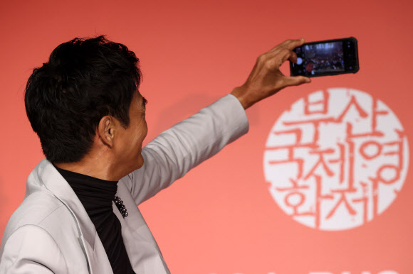 홍콩 배우 저우룬파(주윤발)이 5일 오후 부산 해운대구 KNN시어터에서 제28회 부산국제영화제 올해의 아시아영화인상 기자회견에서 개인 휴대전화로 기념촬영을 하고 있다. 2023.10.5 연합뉴스