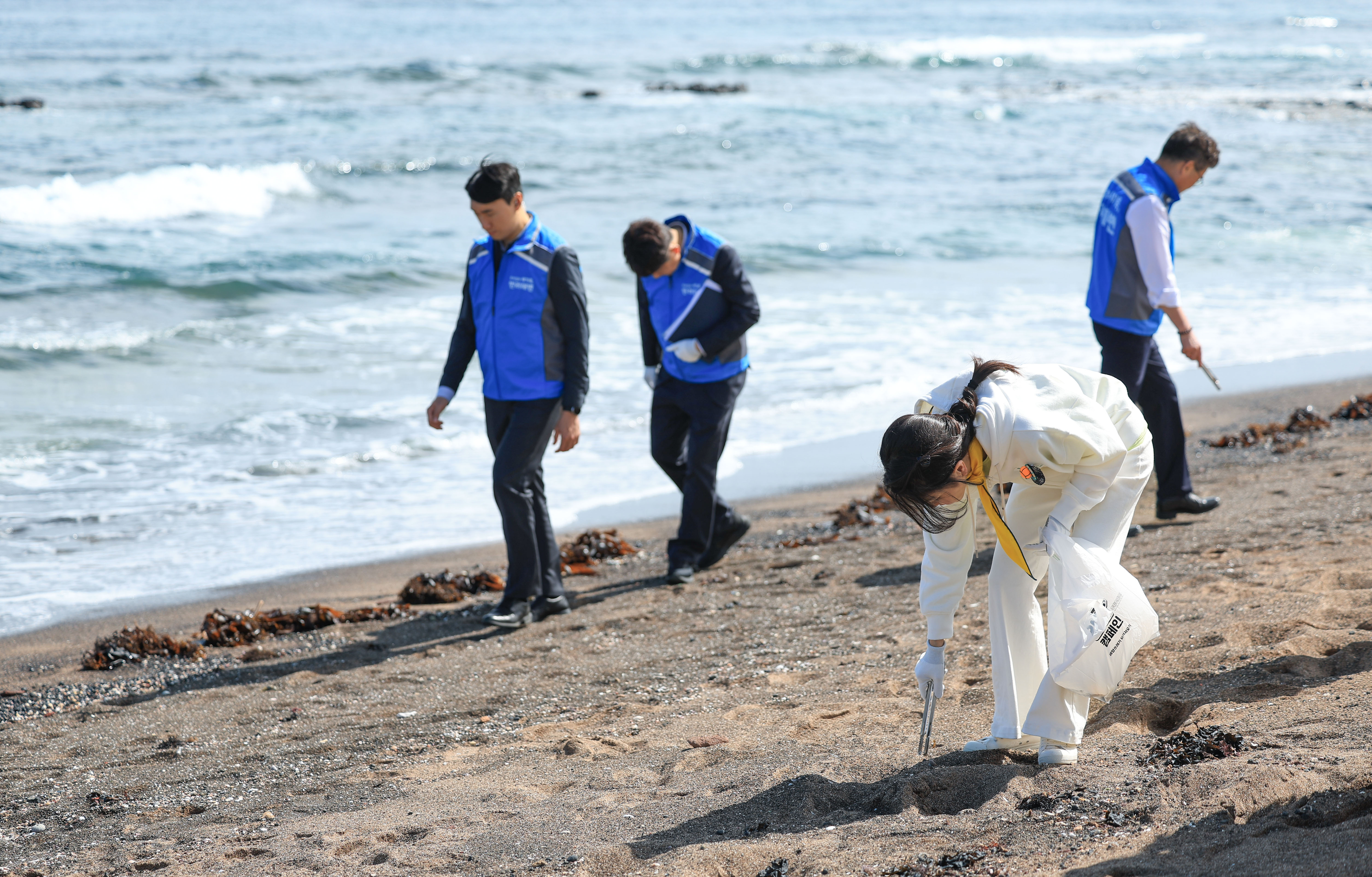 김건희 여사가 지난 6일 제주 서귀포시 광치기 해변에서 반려해변 정화활동에 나서 쓰레기를 줍고 있다.  대통령실 제공