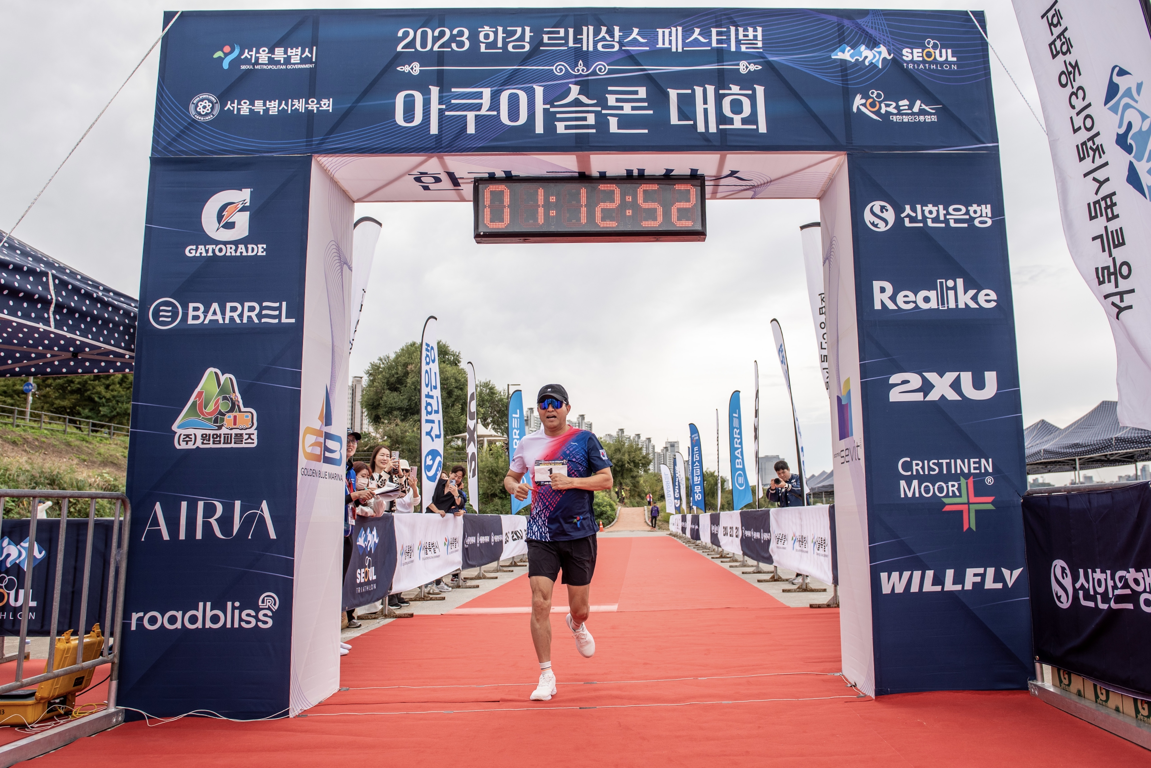 오세훈 서울시장이 8일 오전 잠실수중보 및 잠실한강공원 일대에서 열린 ‘2023 한강 아쿠아슬론대회’ 중 챌린지코스(수영 750m, 달리기5km)에 참가해 잠실한강공원을 달린 뒤 결승지점을 통과하고 있다. 서울시 제공