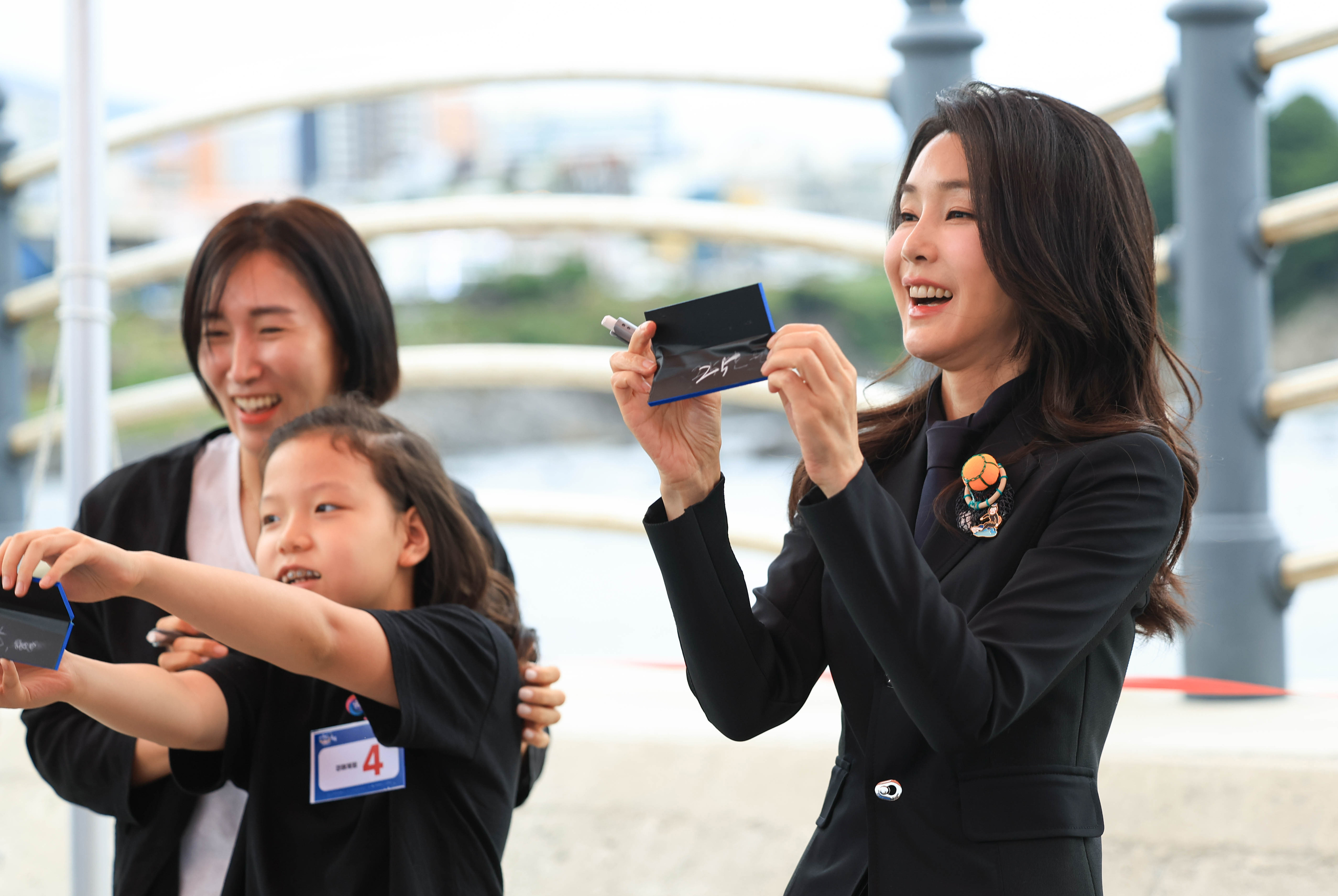 윤석열 대통령 부인 김건희 여사가 6일 제주 서귀포항에서 열린 제4회 제주 서귀포 은갈치 축제 개막식에서 은갈치 경매를 체험해보고 있다.   2023.10.6 대통령실 제공.