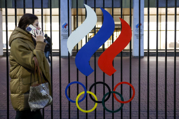 러시아의 한 여성이 모스크바 시내 루츠네츠야 거리에 있는 러시아올림픽위원회(ROC) 본부 건물 앞을 지나가고 있다. 타스 자료사진 연합뉴스